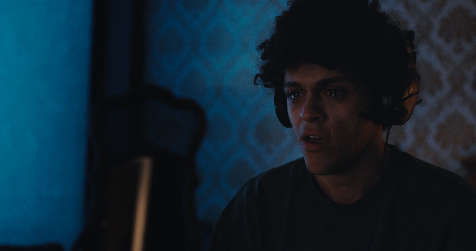 A man lit in blue at night, from Sundered