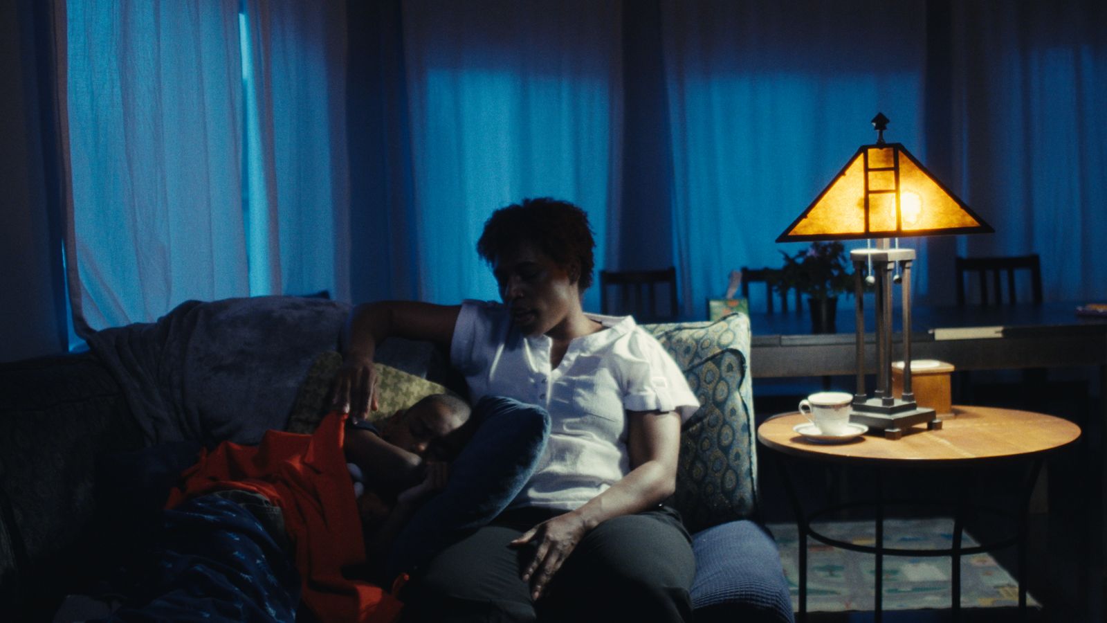 A couple on a couch beside a lamp