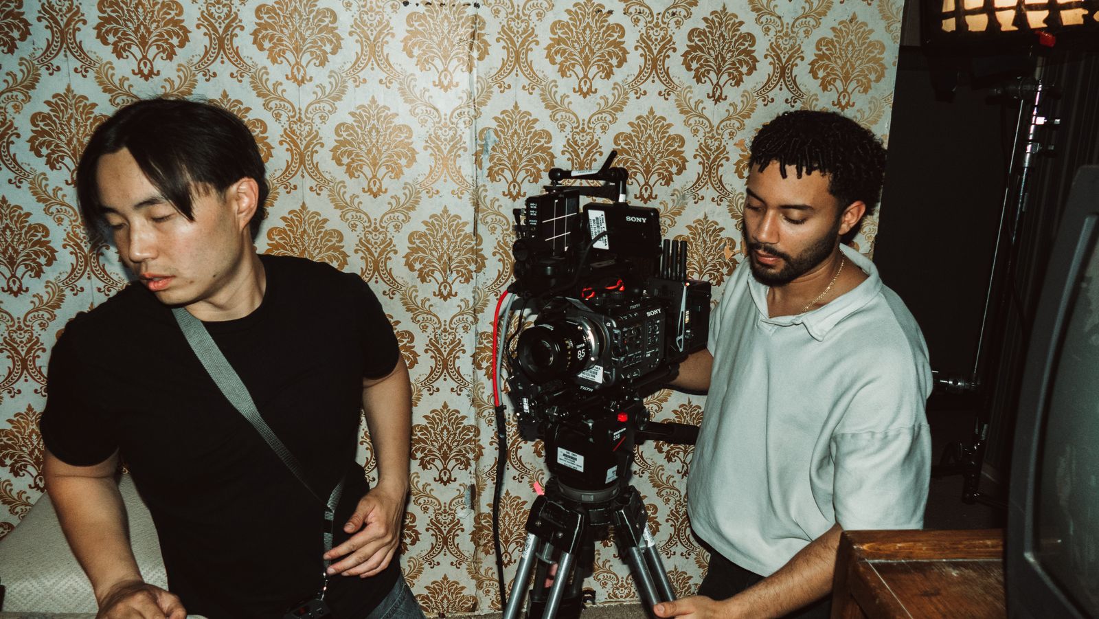 The camera team lining up a shot in a wallpapered room